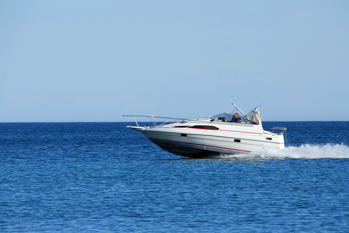 A white speed boat with Raptor liner in blue water in El Paso.
