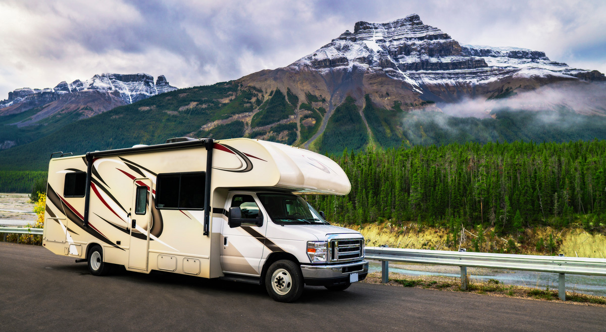 An RV in front of a mountain and forest in El Paso.